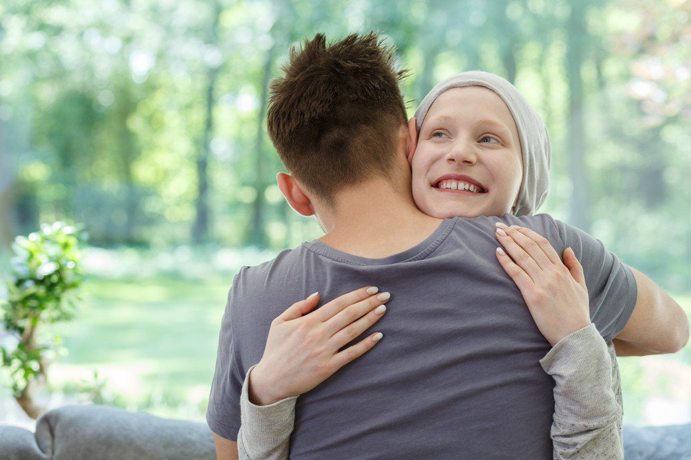 mujer con cáncer siendo abrazada