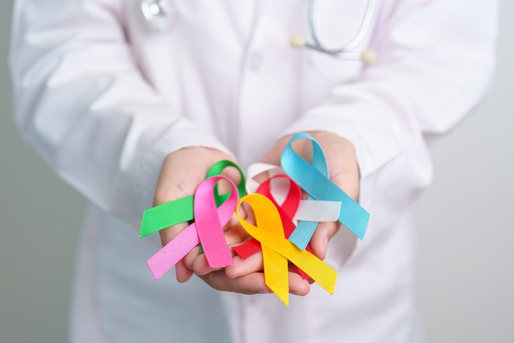 mano sujetando lazos por el día de la lucha contra el cáncer