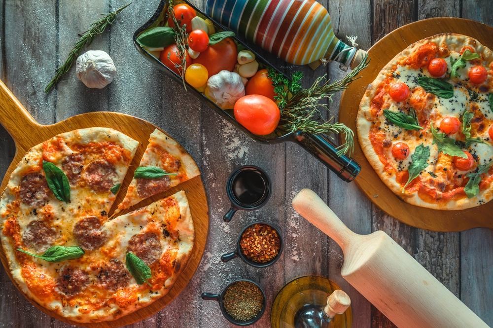 mesa con dos pizzas e ingredientes frescos y naturales